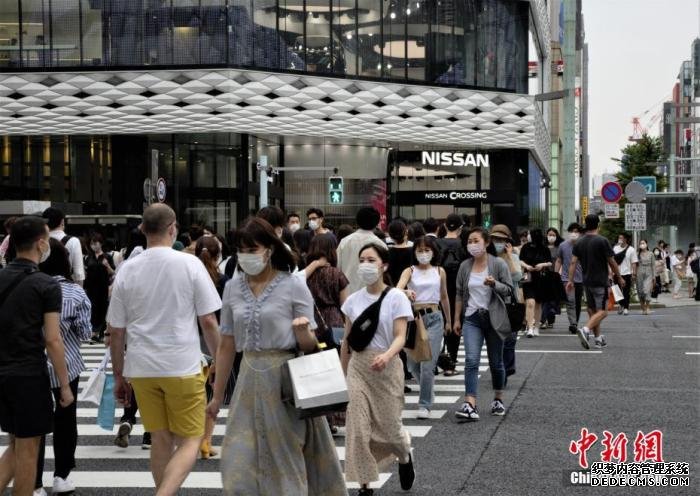 资料图：日本民众佩戴口罩走过东京街头。
中新社记者 吕少威 摄